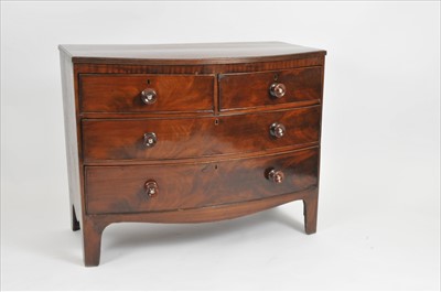 Lot 432 - A bow fronted mahogany and oak veneered chest of two short and two long drawers