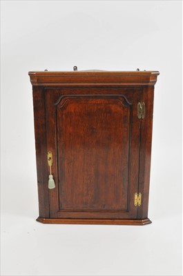 Lot 424 - A George III oak corner cupboard
