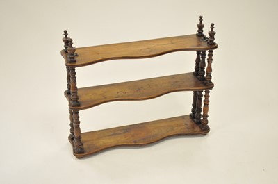 Lot 537 - A small walnut three-tier hanging wall shelf