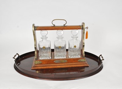 Lot 417 - A Victorian three-bottle oak tantalus with three later decanters and a mahogany butler's tray