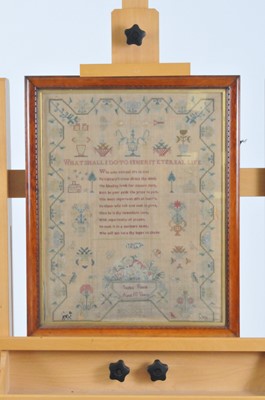 Lot 179 - A George IV sampler, embroidered with urns of...