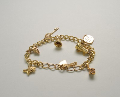 Lot 120 - A yellow metal curb link bracelet with attached charms