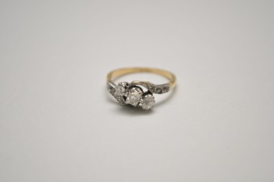 Lot 126 - A three stone diamond cross over ring
