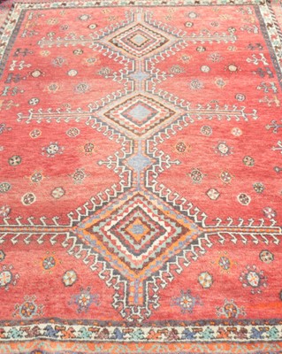 Lot 396 - An old eastern woven wool rug, with a red...