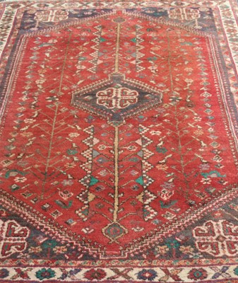 Lot 397 - An old eastern woven wool rug, with a deep red...