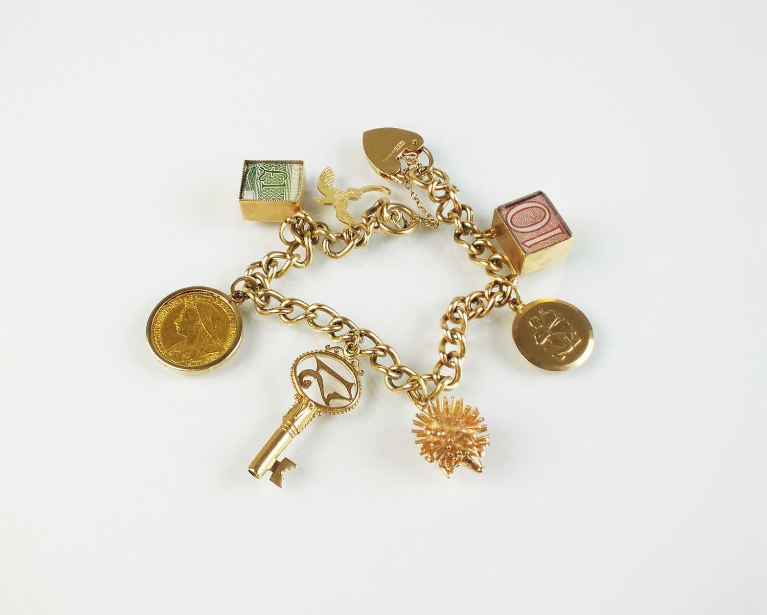 Lot 63 - A 9ct gold curb link bracelet with attached charms