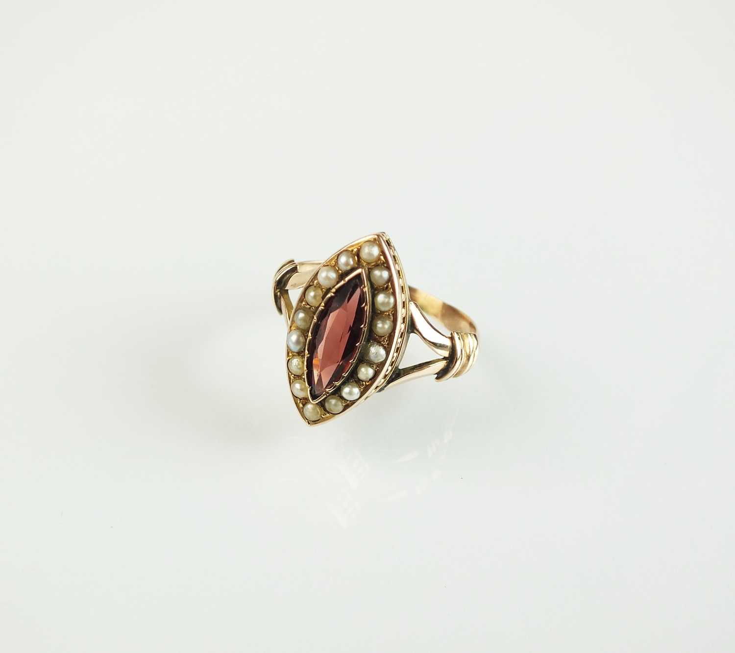 Lot 105 - A garnet and split seed pearl ring