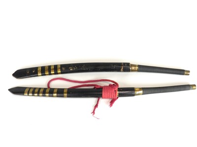 Lot 207 - A pair of Indonesian swords in scabbards, 20th...