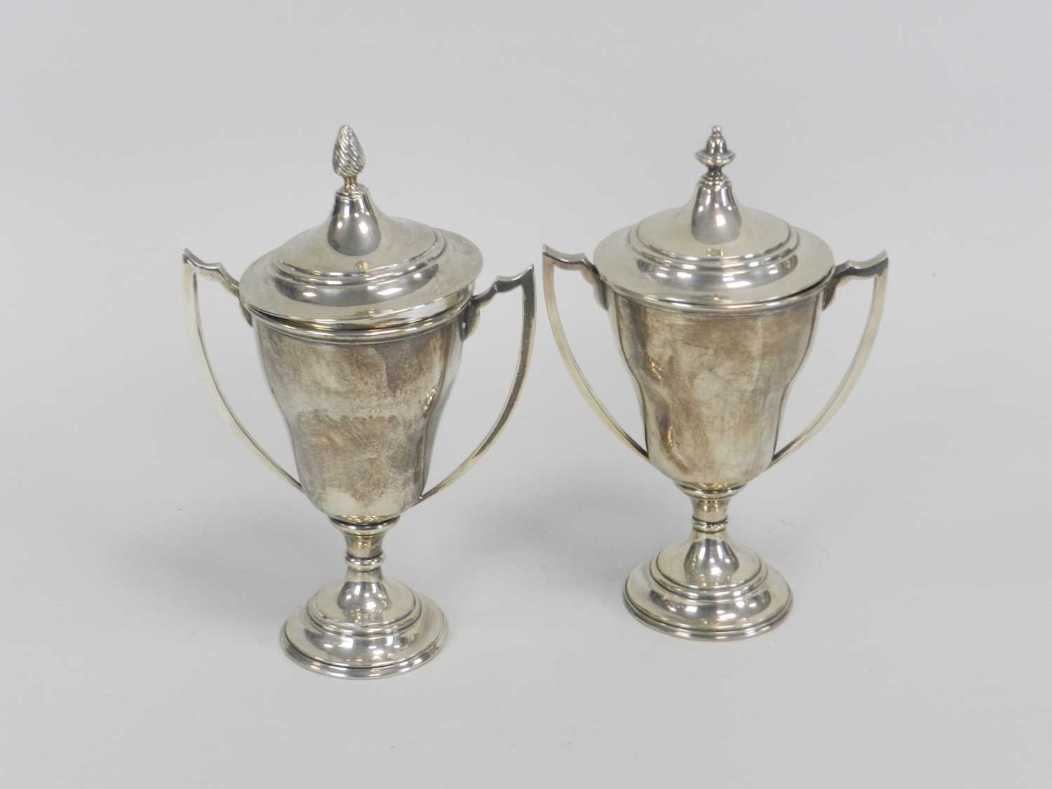 Lot 16 - A near pair of silver trophy cups and covers