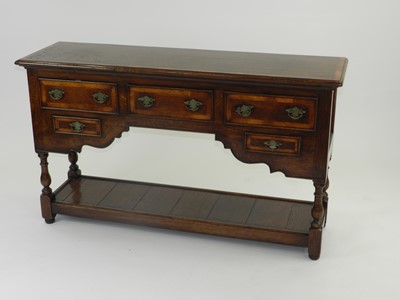 Lot 423 - A small reproduction cross-banded oak dresser...