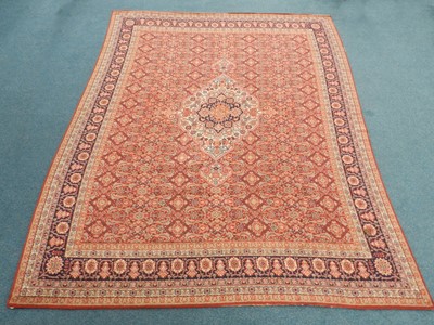 Lot 489 - A large Eastern woven wool carpet, the red...