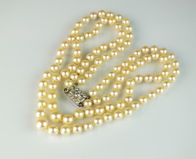 Lot 25 - A two strand graduated cultured pearl necklace with diamond set clasp