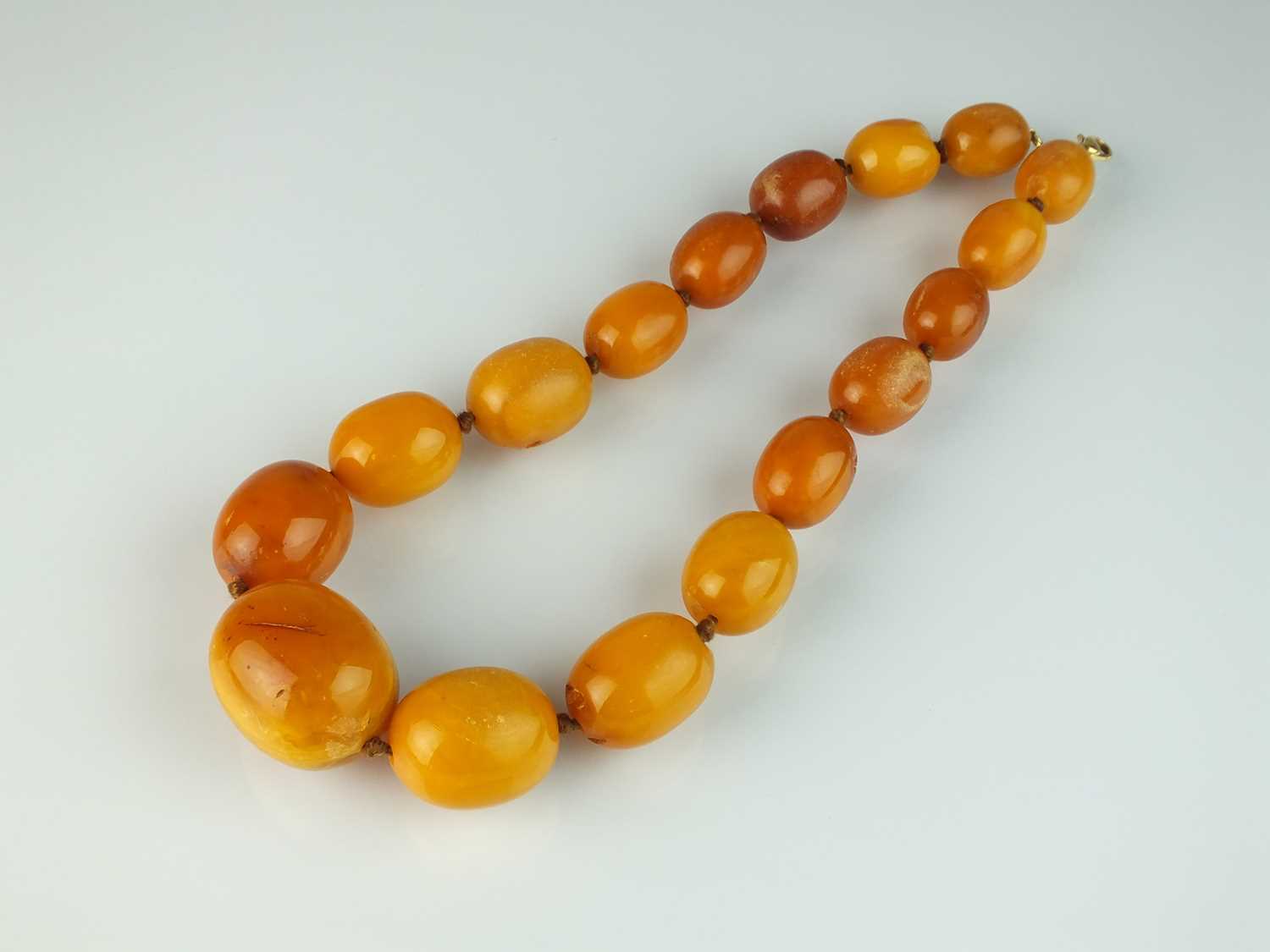 Lot 30 - A graduated oval amber bead necklace