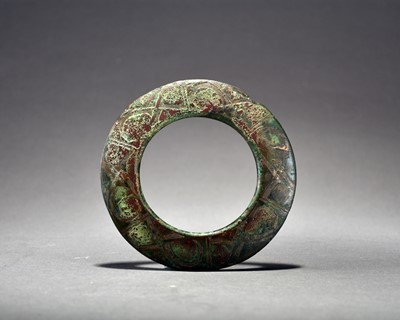 Lot 314 - A Chinese silver-inlaid bronze harness ring, Zhou Dynasty/Warring States