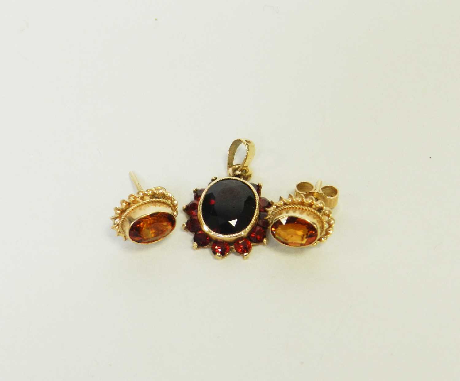 Lot 26 - A garnet pendant and a pair of garnet earrings