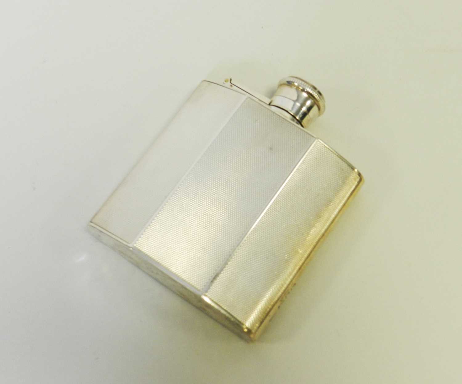 Lot 7 - An engine turned silver hip flask