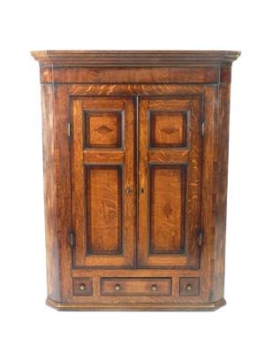 Lot 319 - A George III oak cross-banded hanging corner cupboard