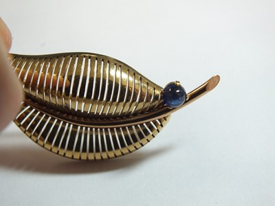 Lot 87 - A 9ct gold cabochon sapphire set leaf brooch