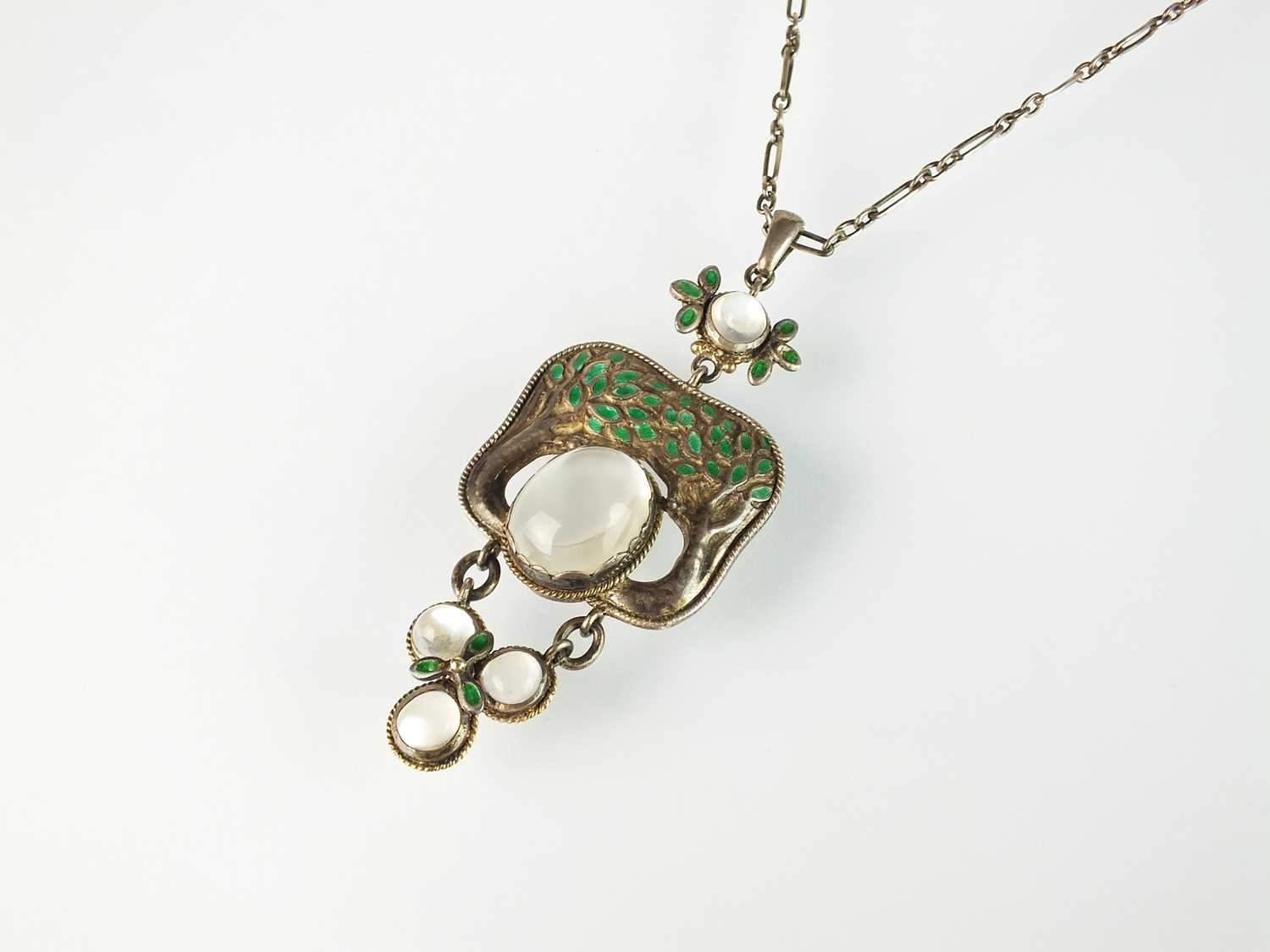 Lot 133 - An Arts and Crafts moonstone and enamel pendant in the style of Jessie M King