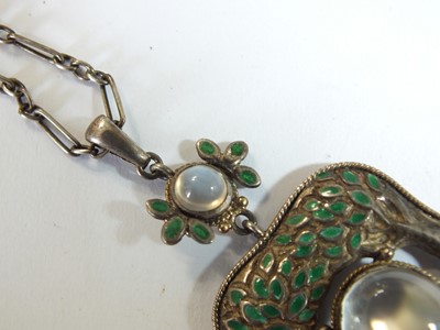 Lot 133 - An Arts and Crafts moonstone and enamel pendant in the style of Jessie M King