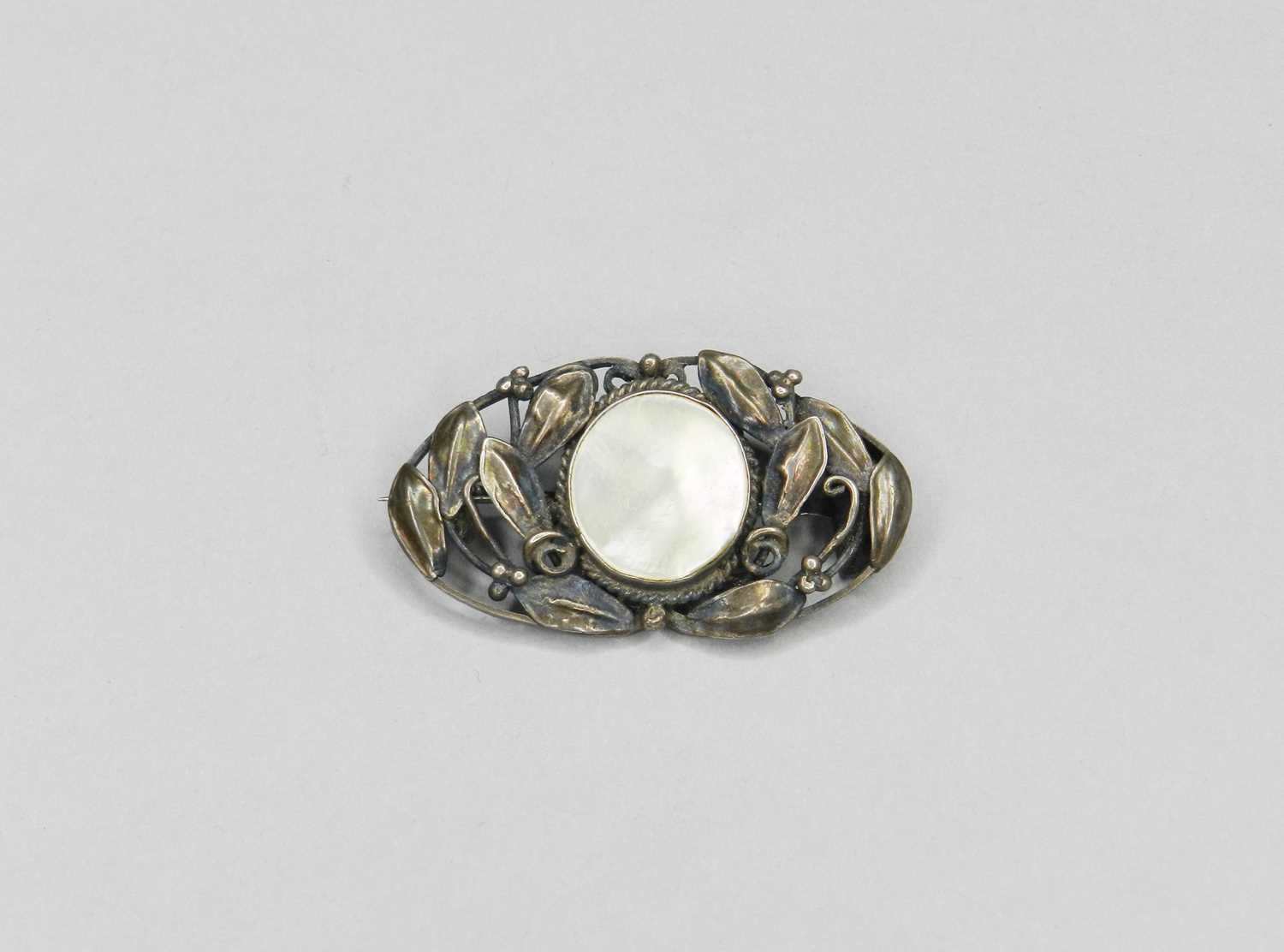 Lot 168 - An Art Nouveau white metal mother of pearl set brooch