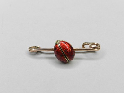 Lot 170 - An enamelled yellow metal ladybird bar brooch