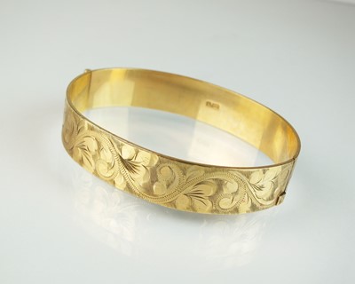 Lot 90 - A 9ct gold bright cut engraved hinged bangle