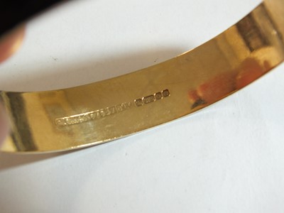 Lot 90 - A 9ct gold bright cut engraved hinged bangle