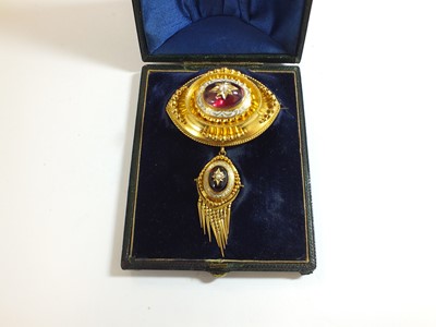 Lot 125 - A Victorian garnet, pearl and enamel locket brooch
