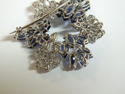 Lot 105 - A diamond and sapphire stylised leaf cluster brooch