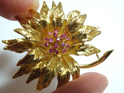 Lot 64 - An 18ct gold ruby set flower brooch