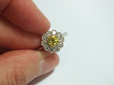 Lot 57 - A yellow and white diamond floral cluster ring