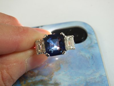 Lot 89 - An 18ct white gold three stone sapphire and diamond ring