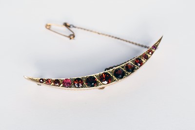 Lot 120 - A 9ct gold graduated garnet crescent brooch