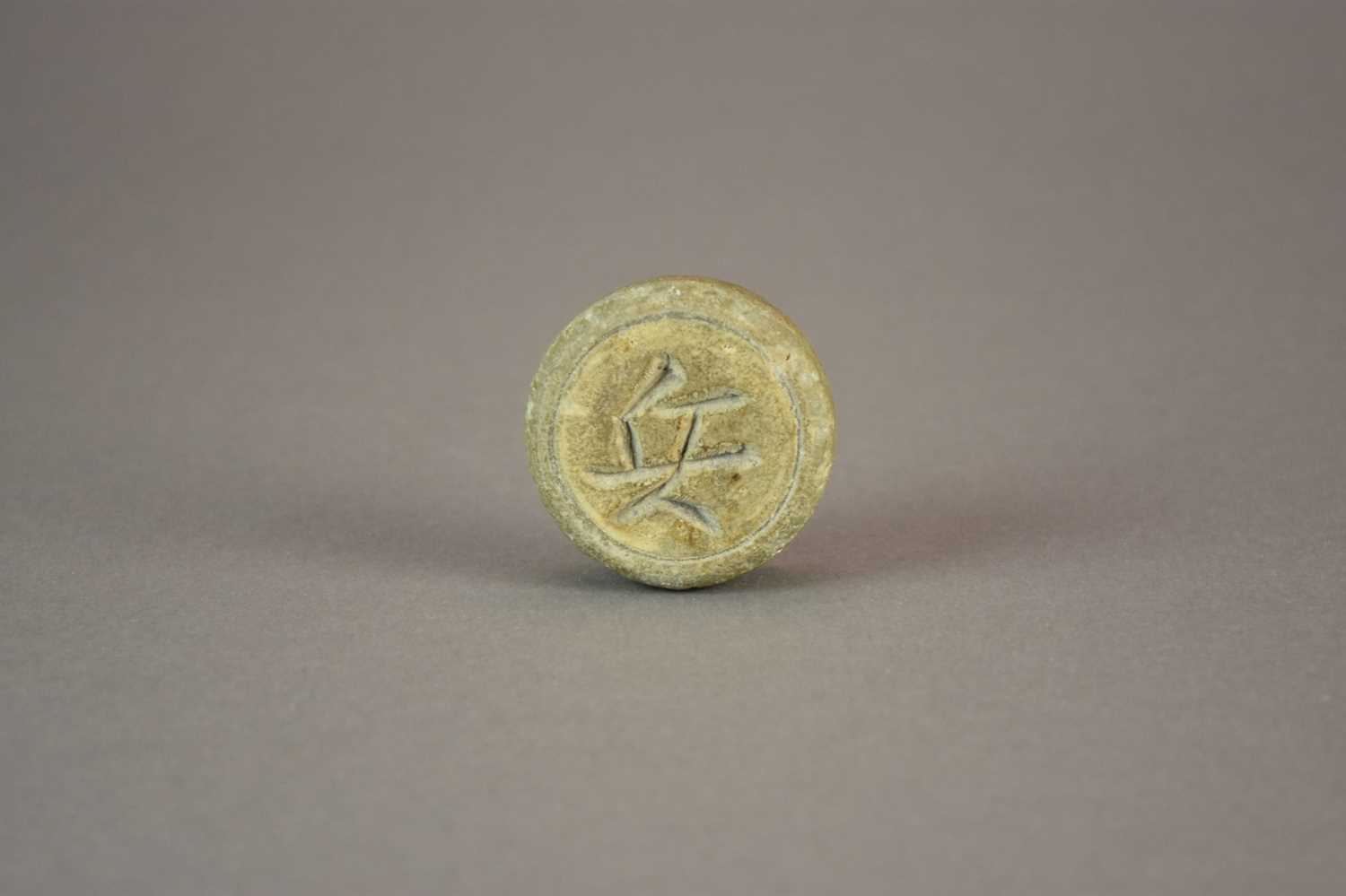 Lot 11 - A Chinese Longquan celadon xiangqi chess piece, possibly Song Dynasty