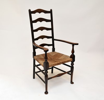 Lot 530 - An oak ladder back rush seated open armchair