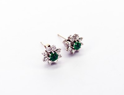 Lot 84 - A pair of 18ct white gold emerald and diamond floral cluster earrings