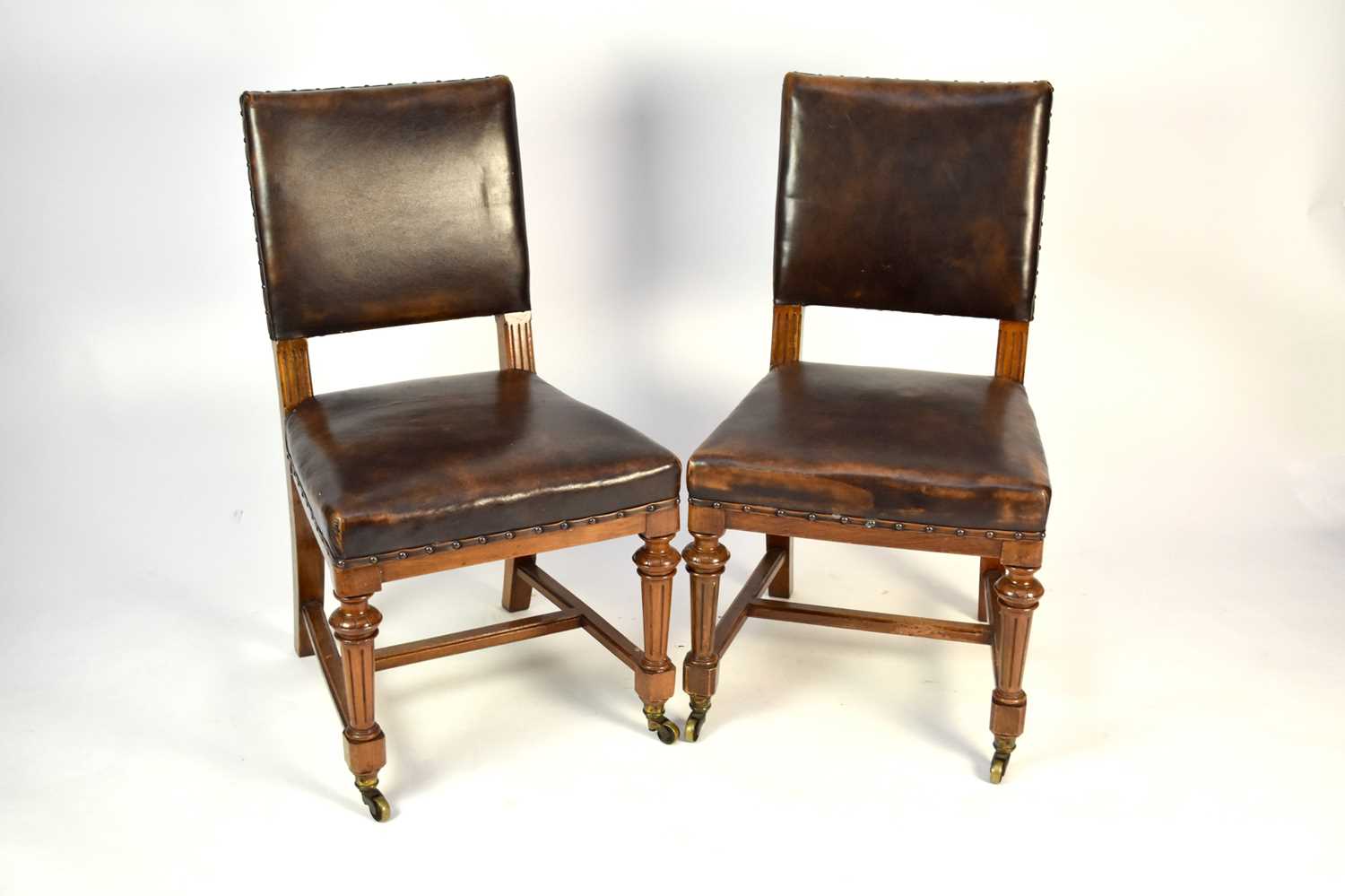 Lot 538 - A set of 11, late 19th century, walnut dining chairs, by Gillow, hide covered and close-nailed