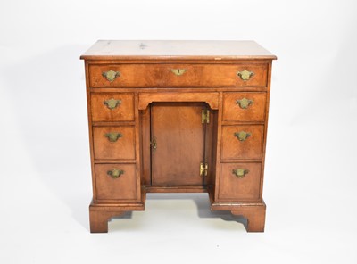 Lot 511 - A George II style walnut kneehole desk