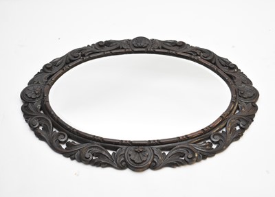 Lot 514 - A carved oak oval wall mirror