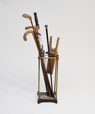 Lot 391 - A Victorian brass and iron stick stand with various sticks and a boot jack