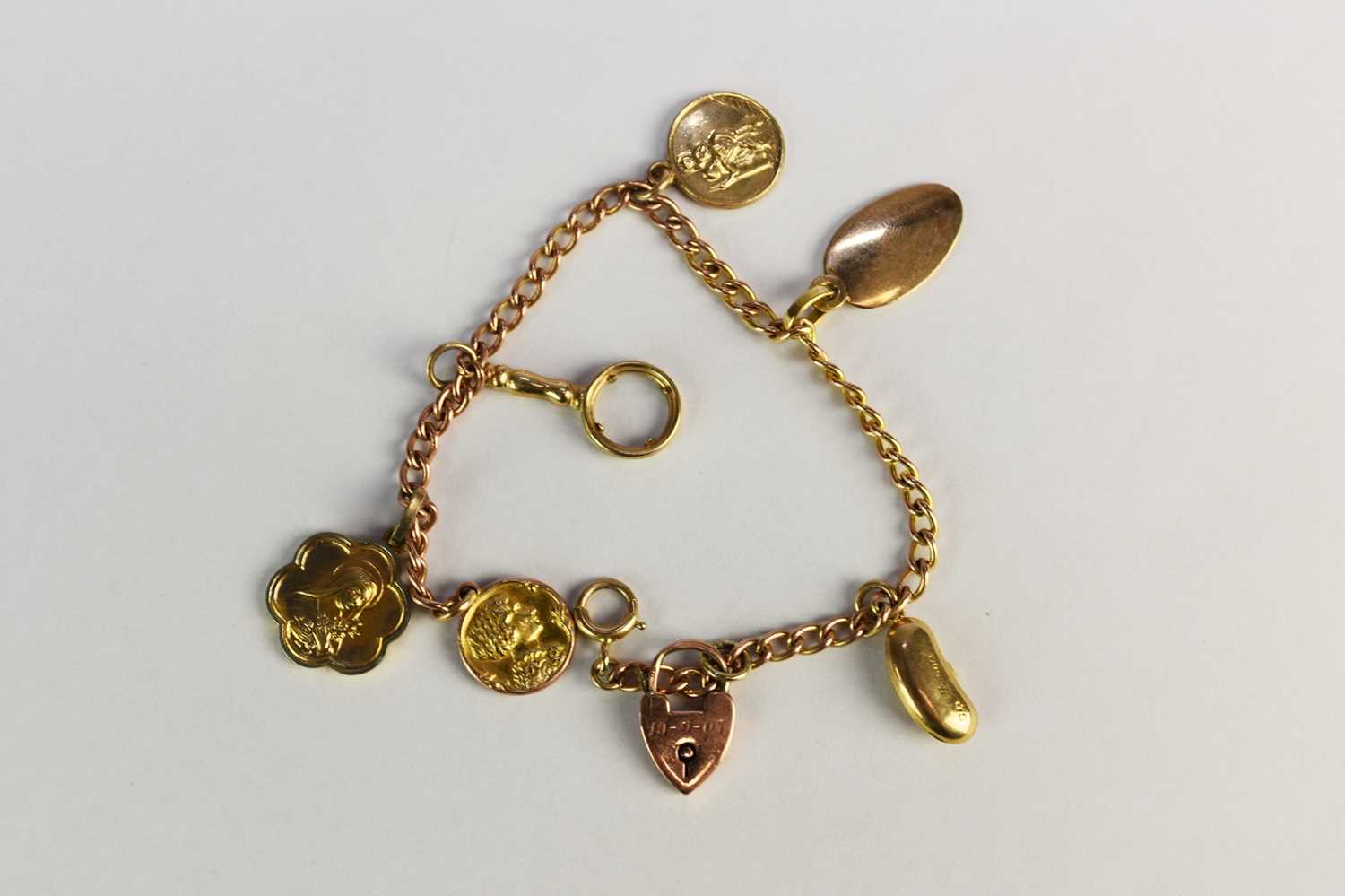 Lot 41 - A yellow metal curb link bracelet with charms