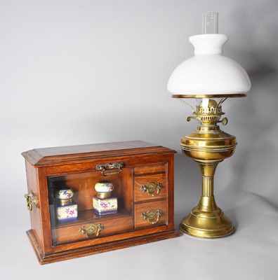 Lot 407 - An Edwardian oak desk companion and a brass oil lamp