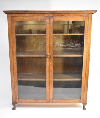 Lot 484 - A mid-20th century oak glazed bookcase