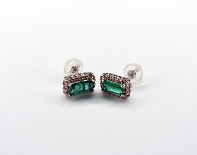 Lot 125 - A pair of 18ct white gold emerald and diamond cluster stud earrings