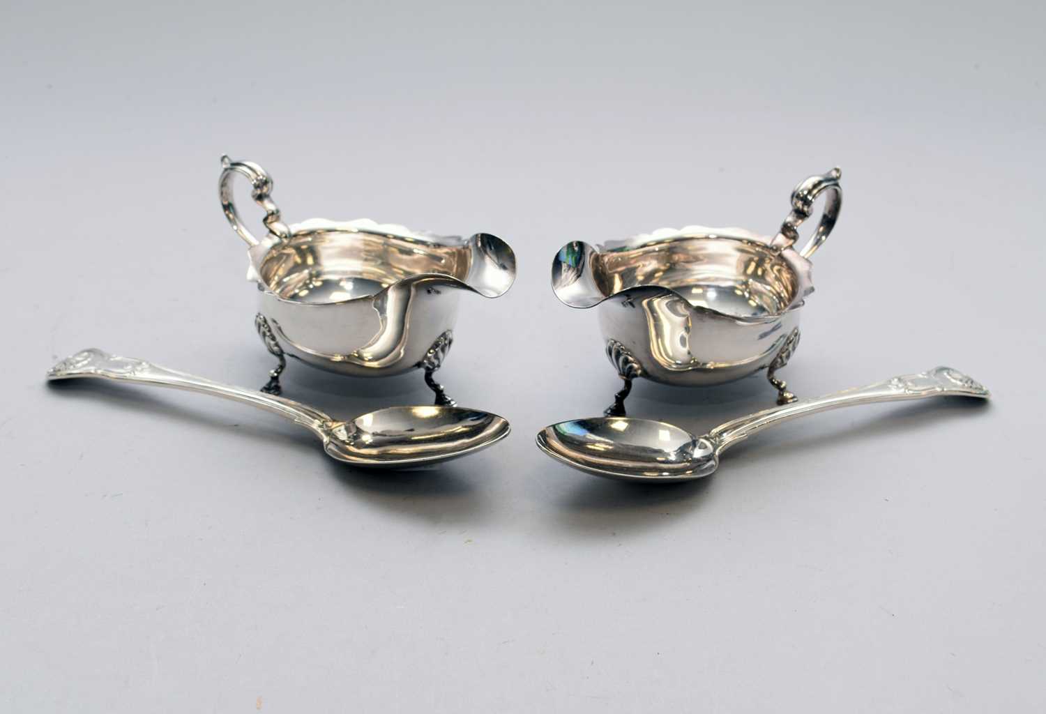 Lot 15 - A pair of silver sauce boats and a pair of silver spoons
