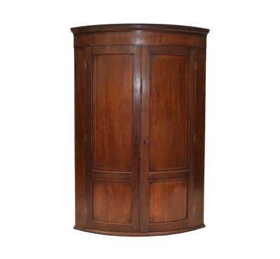 Lot 387 - A George III mahogany bow-fronted hanging corner cupboard