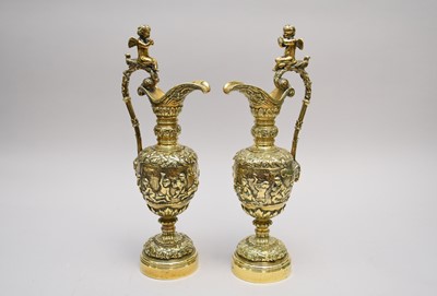 Lot 338 - A pair of cast brass wine ewers and a pair of brass and ceramic aesthetic movement candlesticks