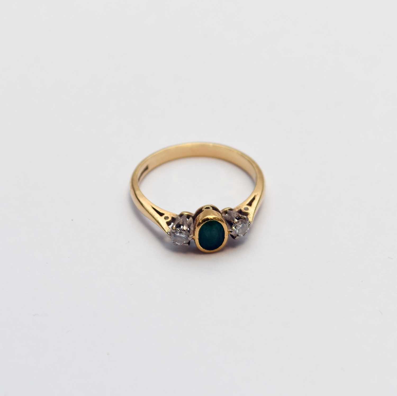 Lot 56 - An 18ct gold three stone emerald and diamond ring