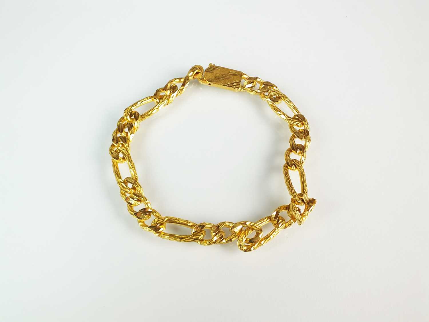 Lot 64 - A yellow metal textured curb link bracelet